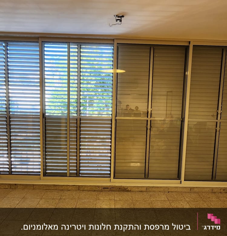 תריסי אלומיניום על חלון גדול בחדר ריק